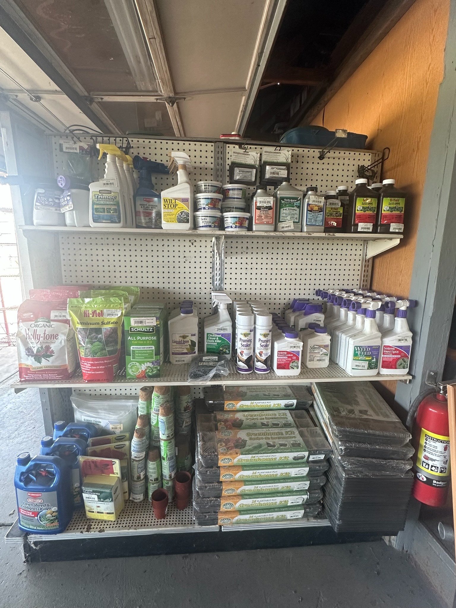 Garden care products, potting kits, and plant supplies on nursery shelves